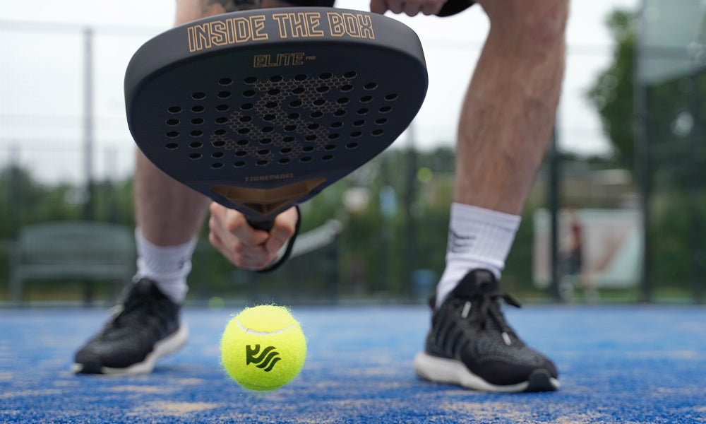 Zwarte padel racket voor beginners die een padel bal opstuit