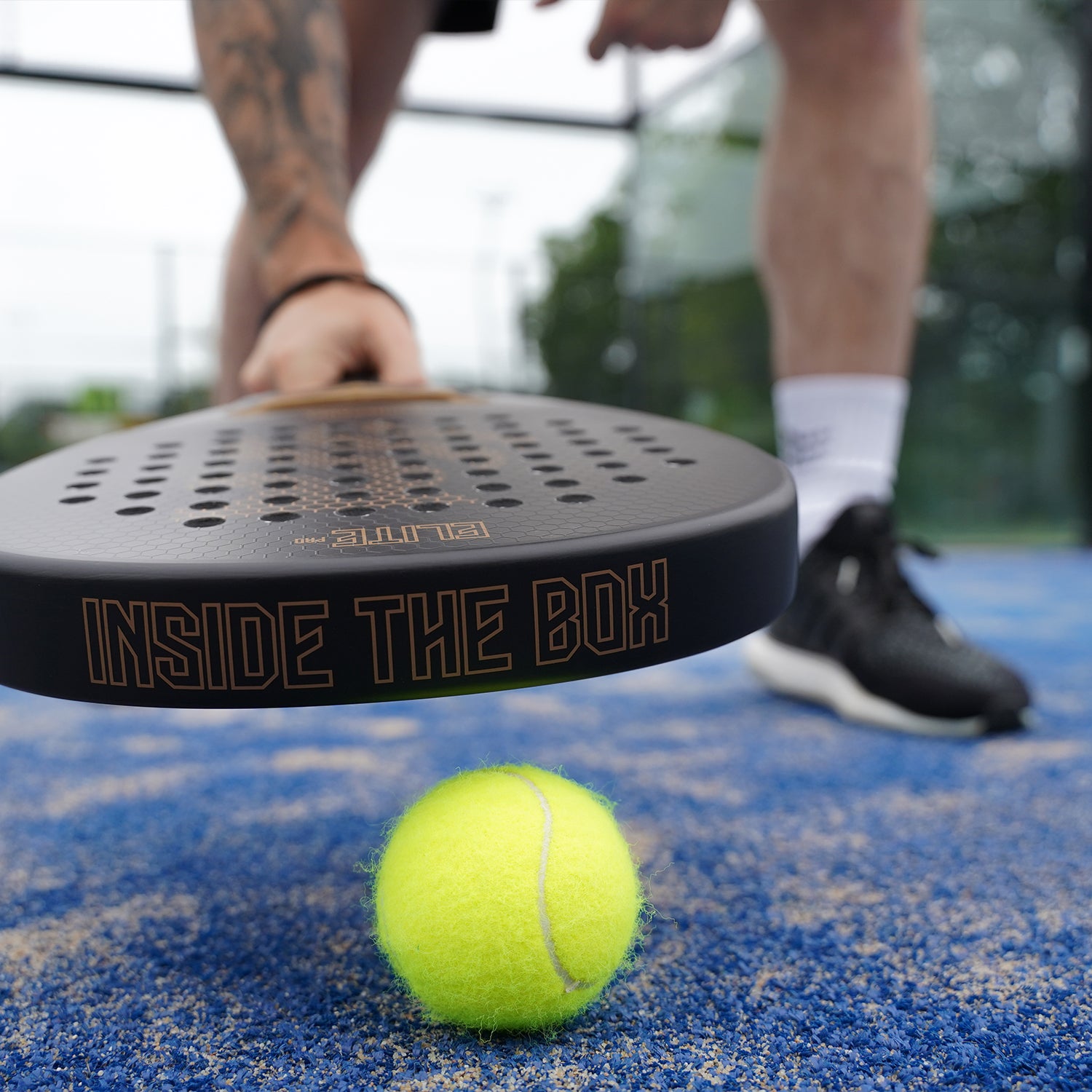 Man met zwarte padel racket voor beginners met een padel bal