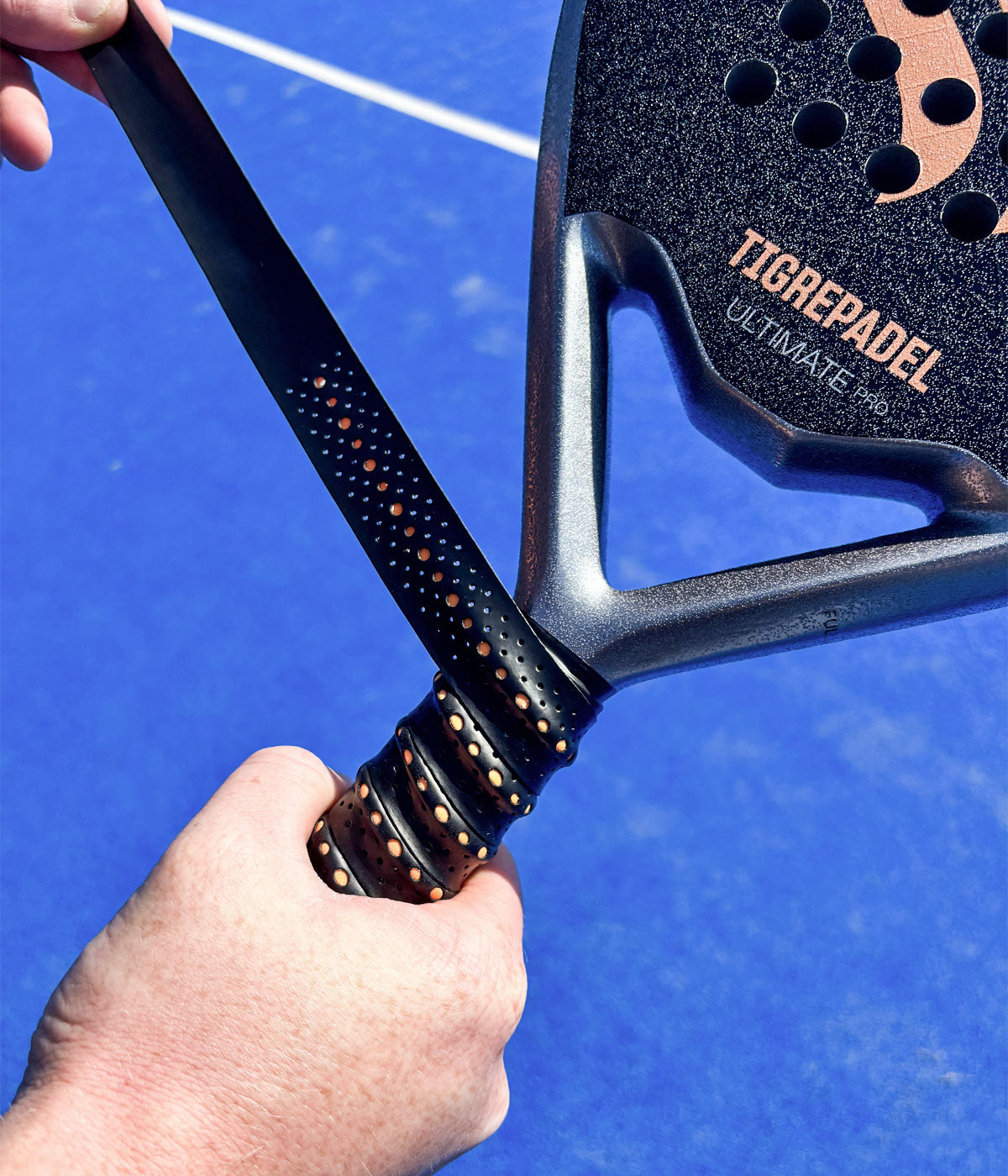 Speler brengt zwarte TigrePadel Contour Max padel overgrip met 3D-ribbelstructuur en verhoogde rand aan op een padelracket